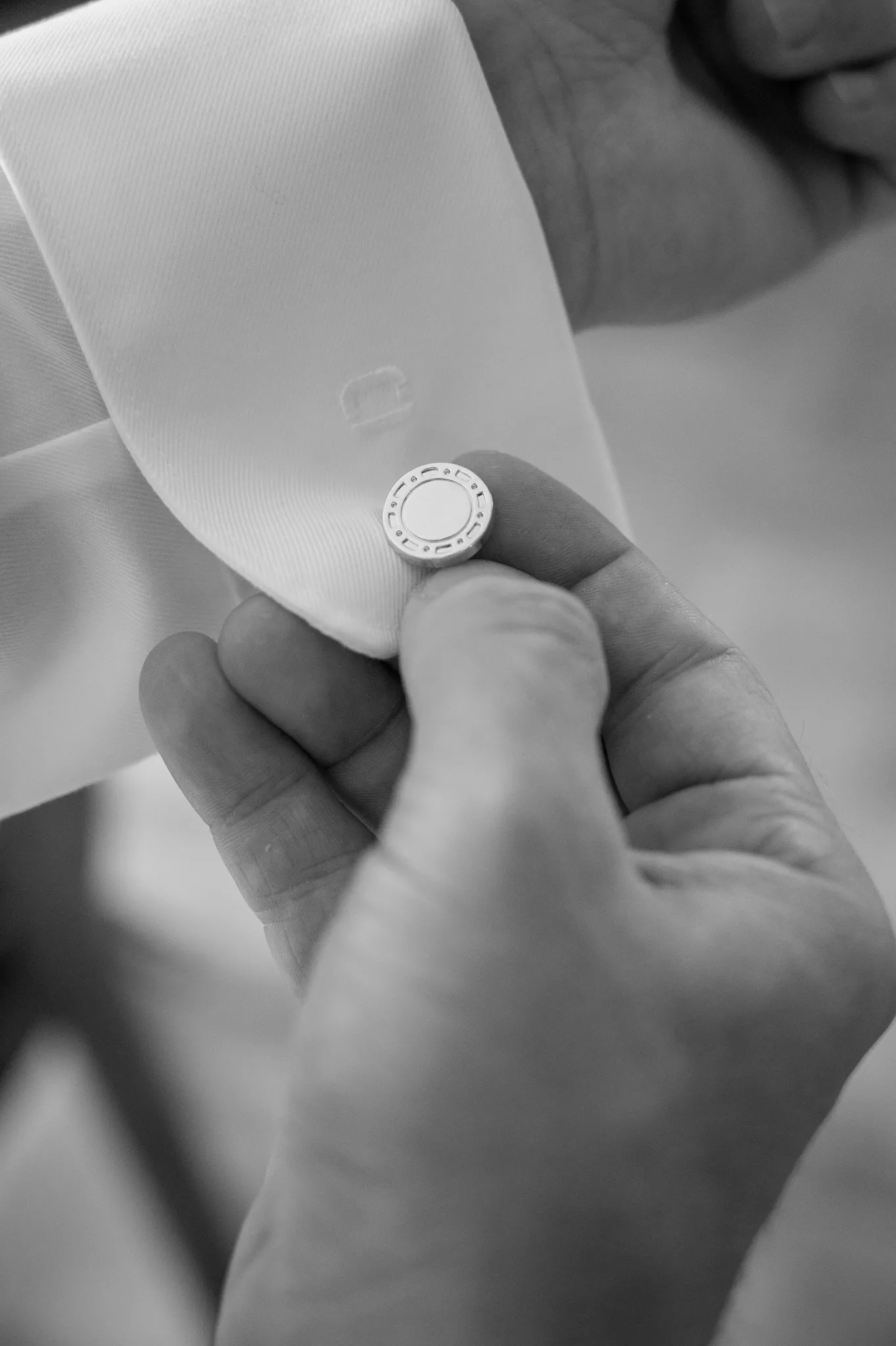 Eine Hand richtet Daniels Armbanduhr am Hemdärmel.
