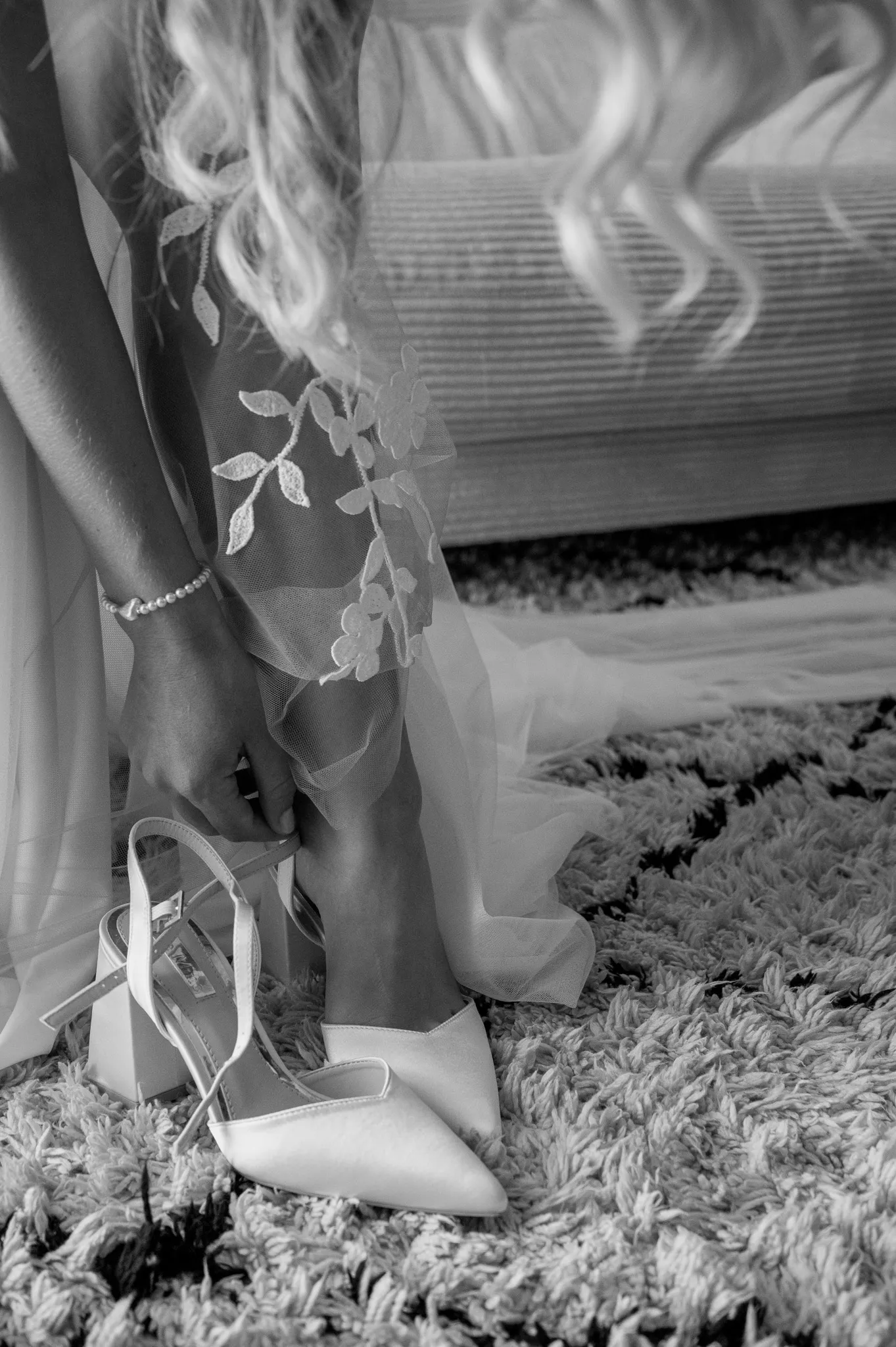 Hochzeitskleid und Schuhe liegen als Schwarz-Weiß-Detail bereit.