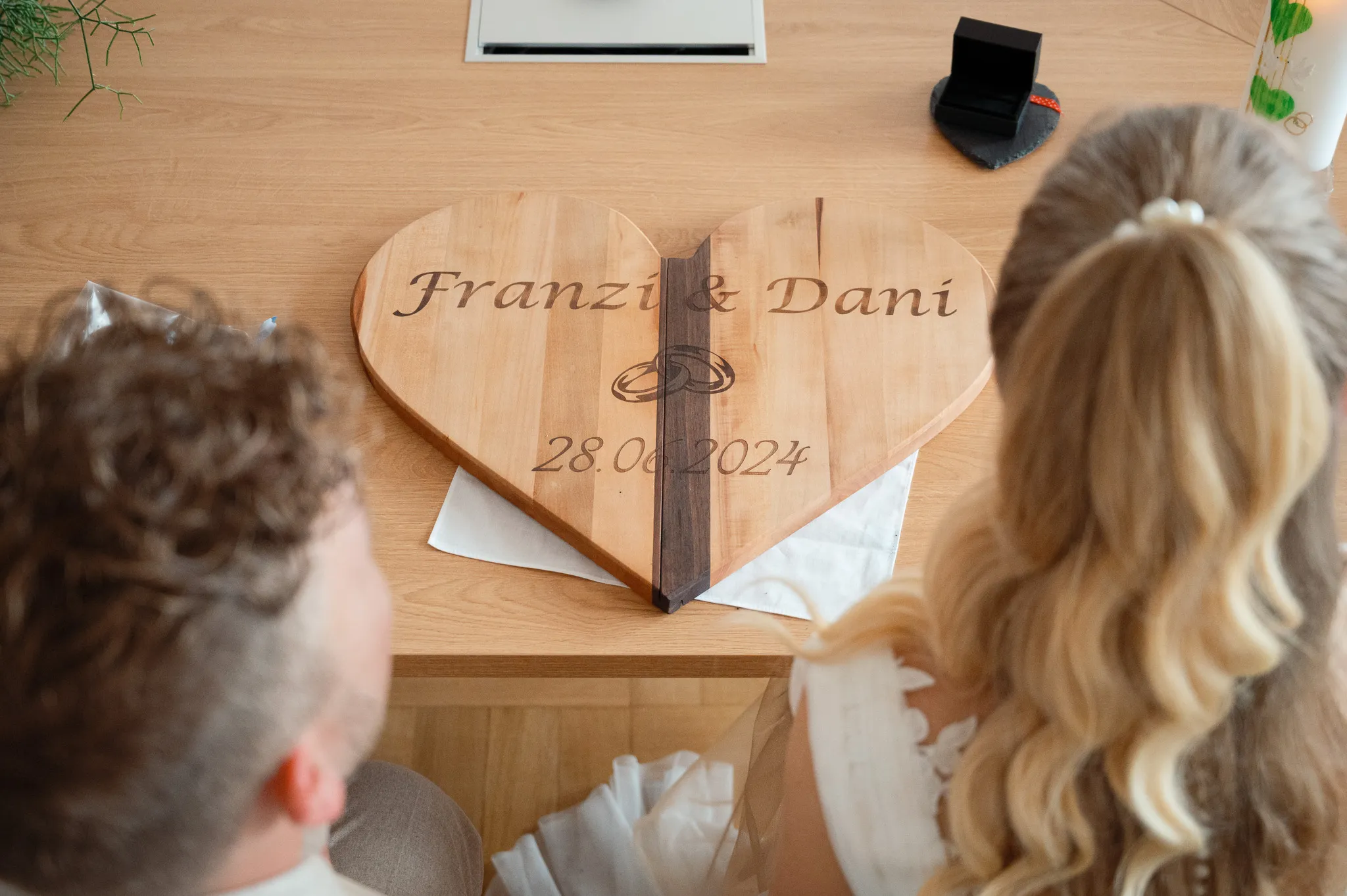 Ein Holzherz mit den Namen Franziska und Daniel liegt auf dem Tisch.