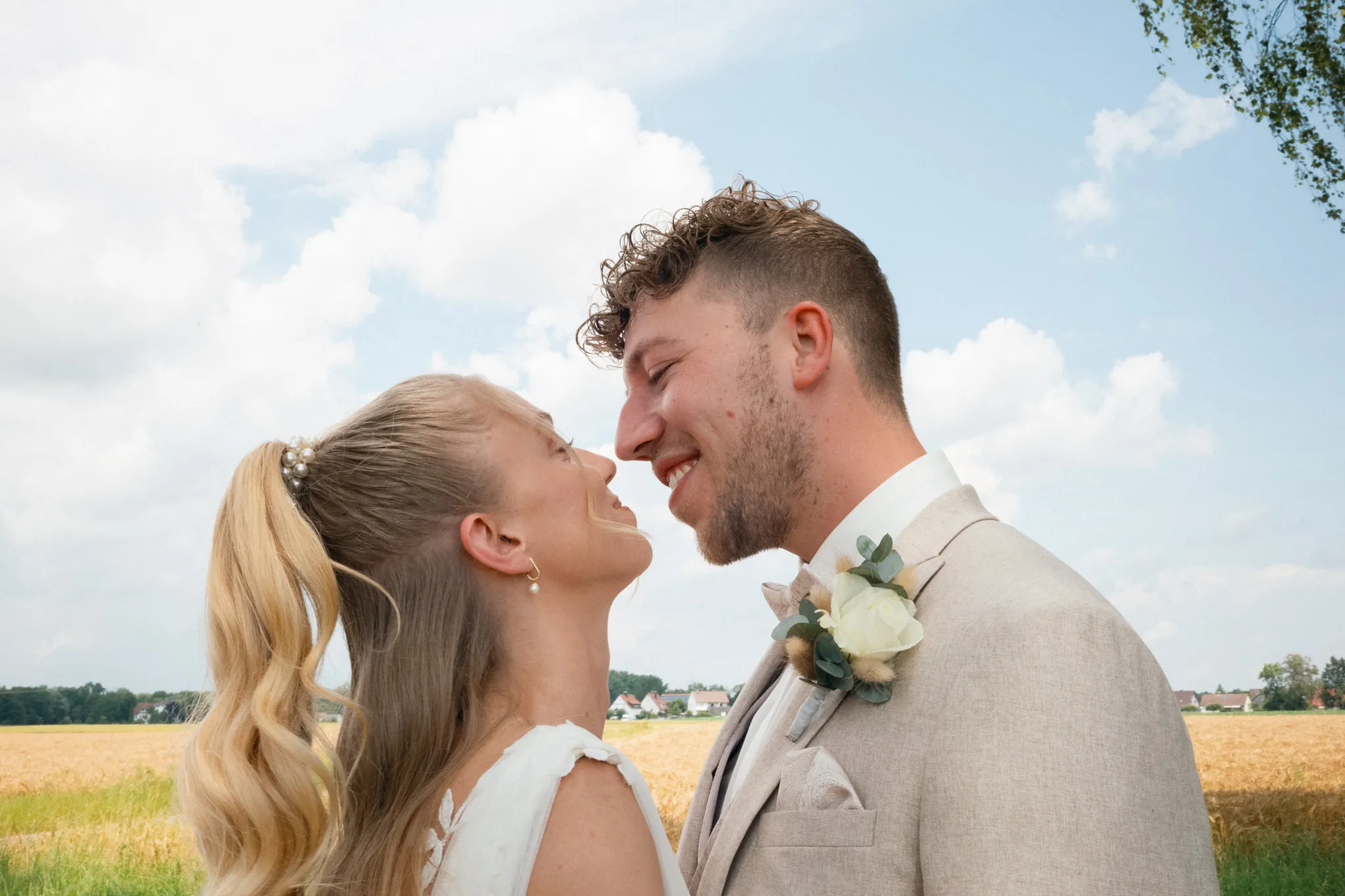 Franziska und Daniel lachen sich vor einem Feld an.