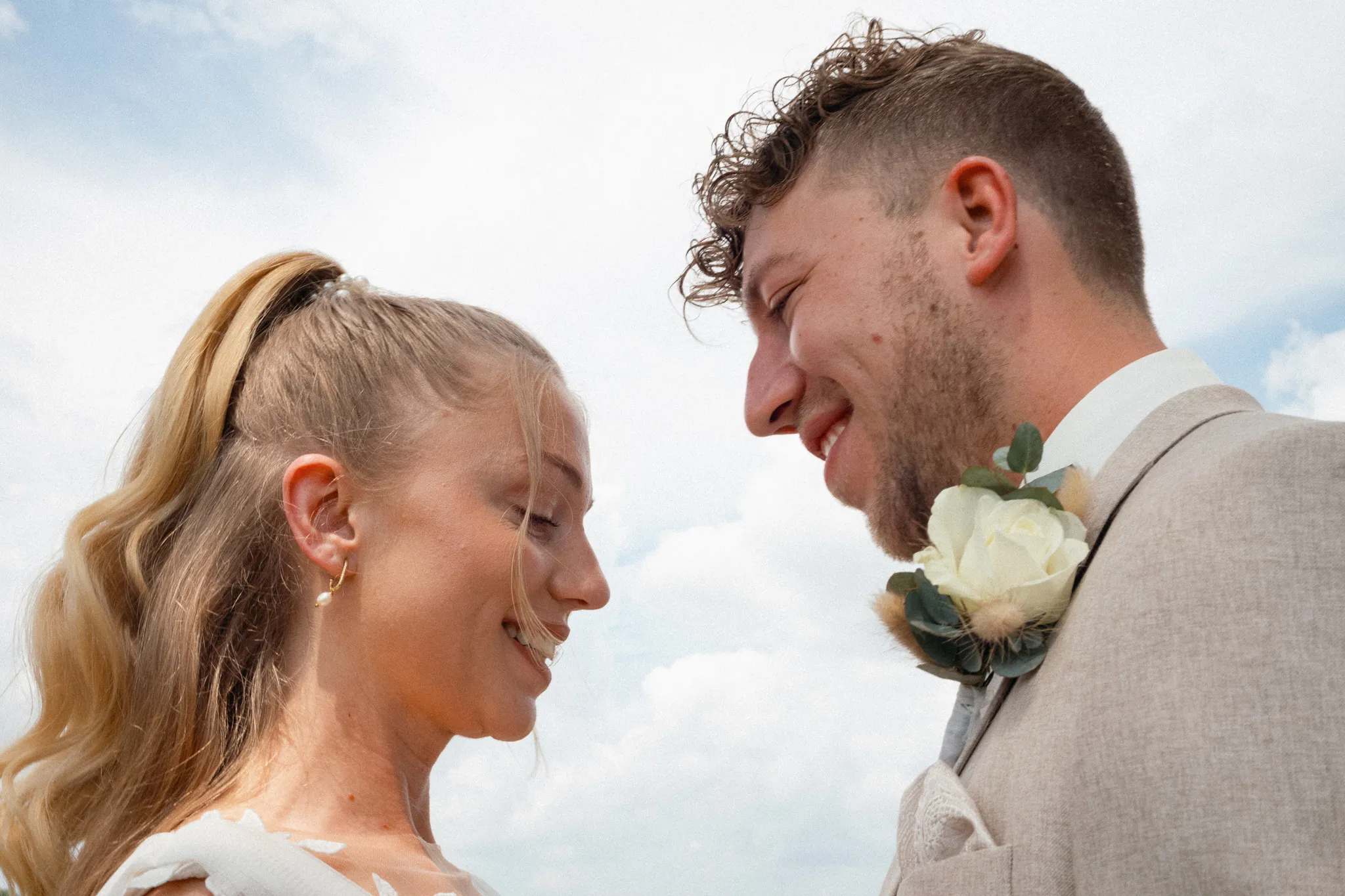 Franziska und Daniel stehen Stirn an Stirn unter freiem Himmel.