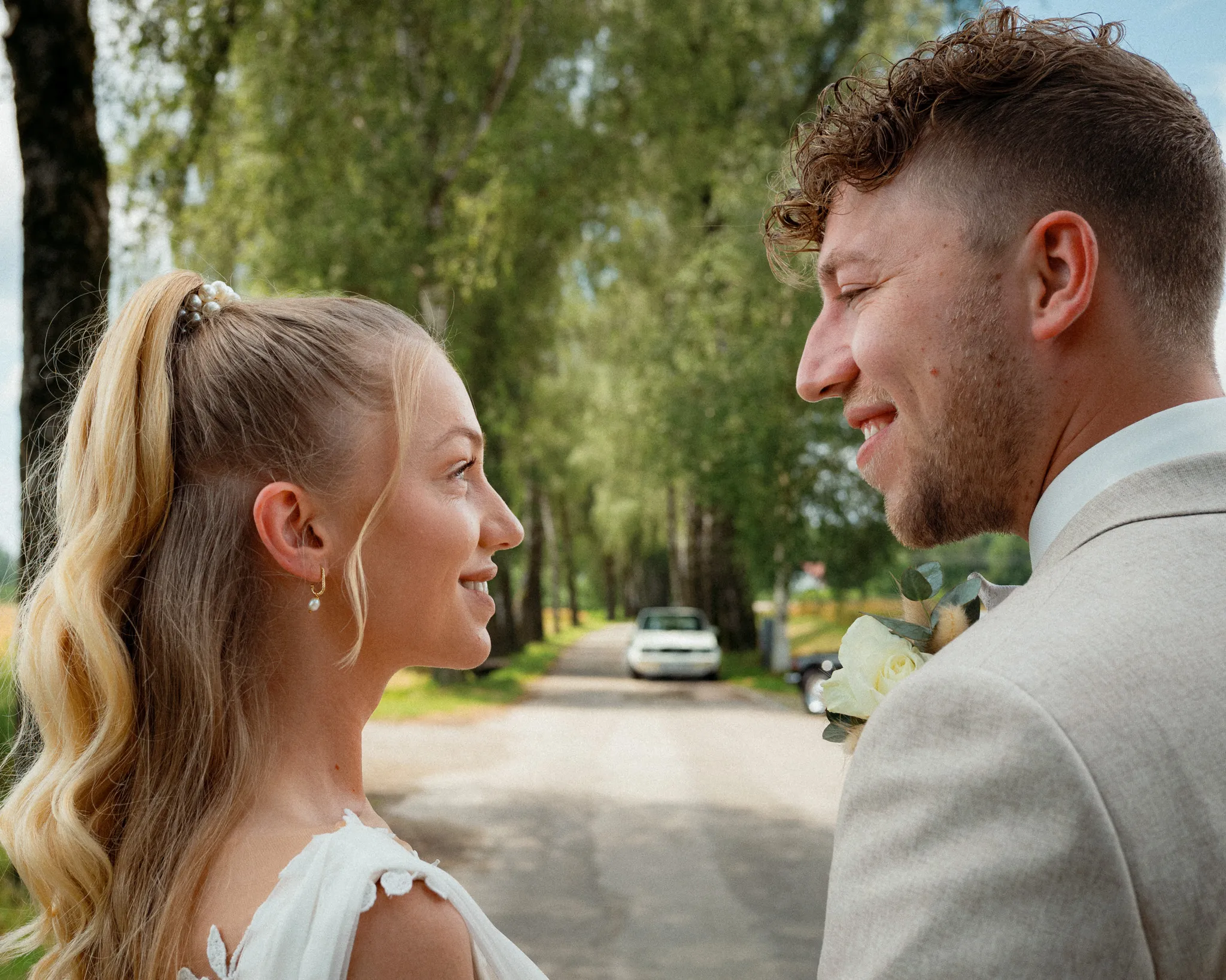 Franziska und Daniel schauen sich auf einer von Bäumen gesäumten Straße an.