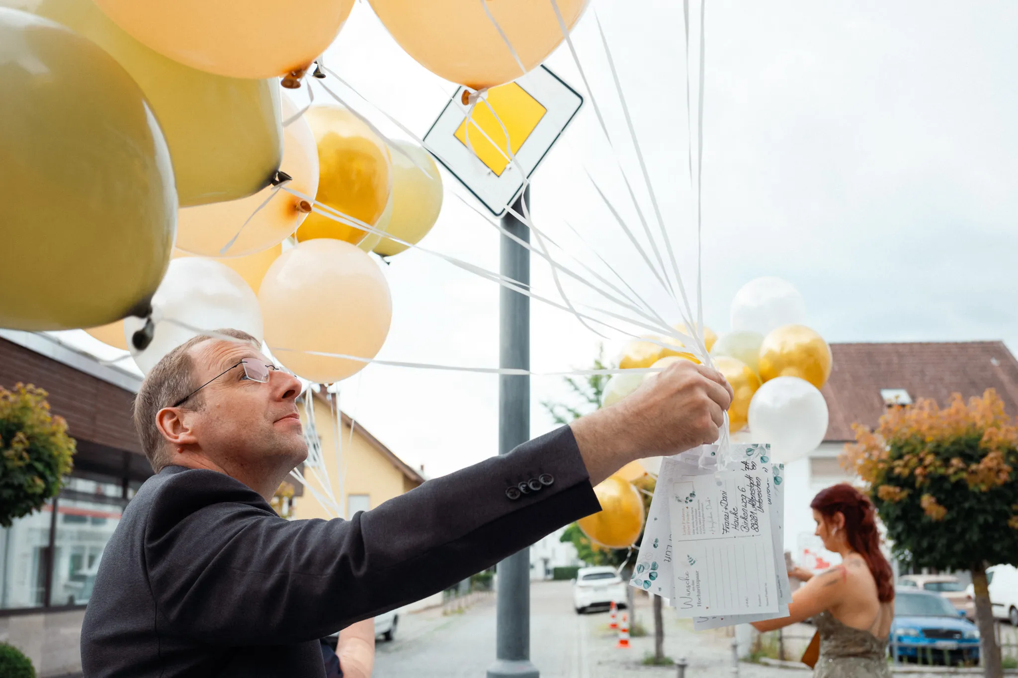 Ein Gast lässt goldene und weiße Luftballons steigen.