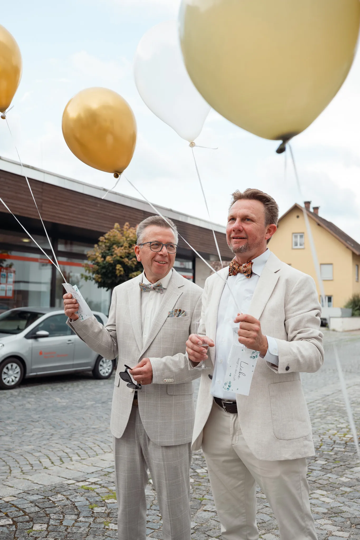 Daniel hält mit einem Gast die Bänder der Luftballons.