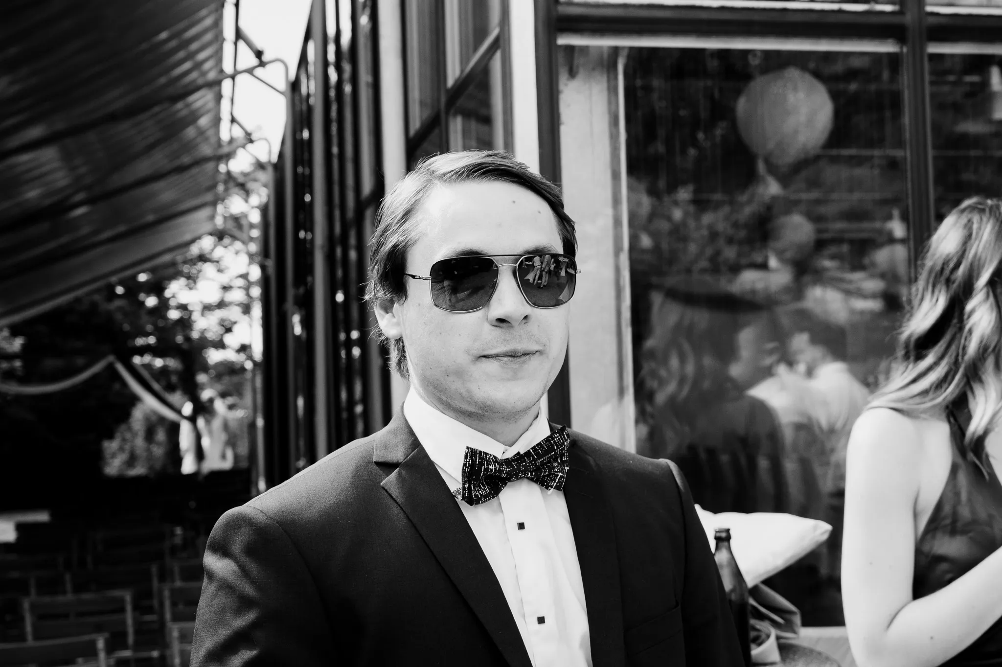 Ein Gast mit Fliege und Sonnenbrille blickt in die Kamera.