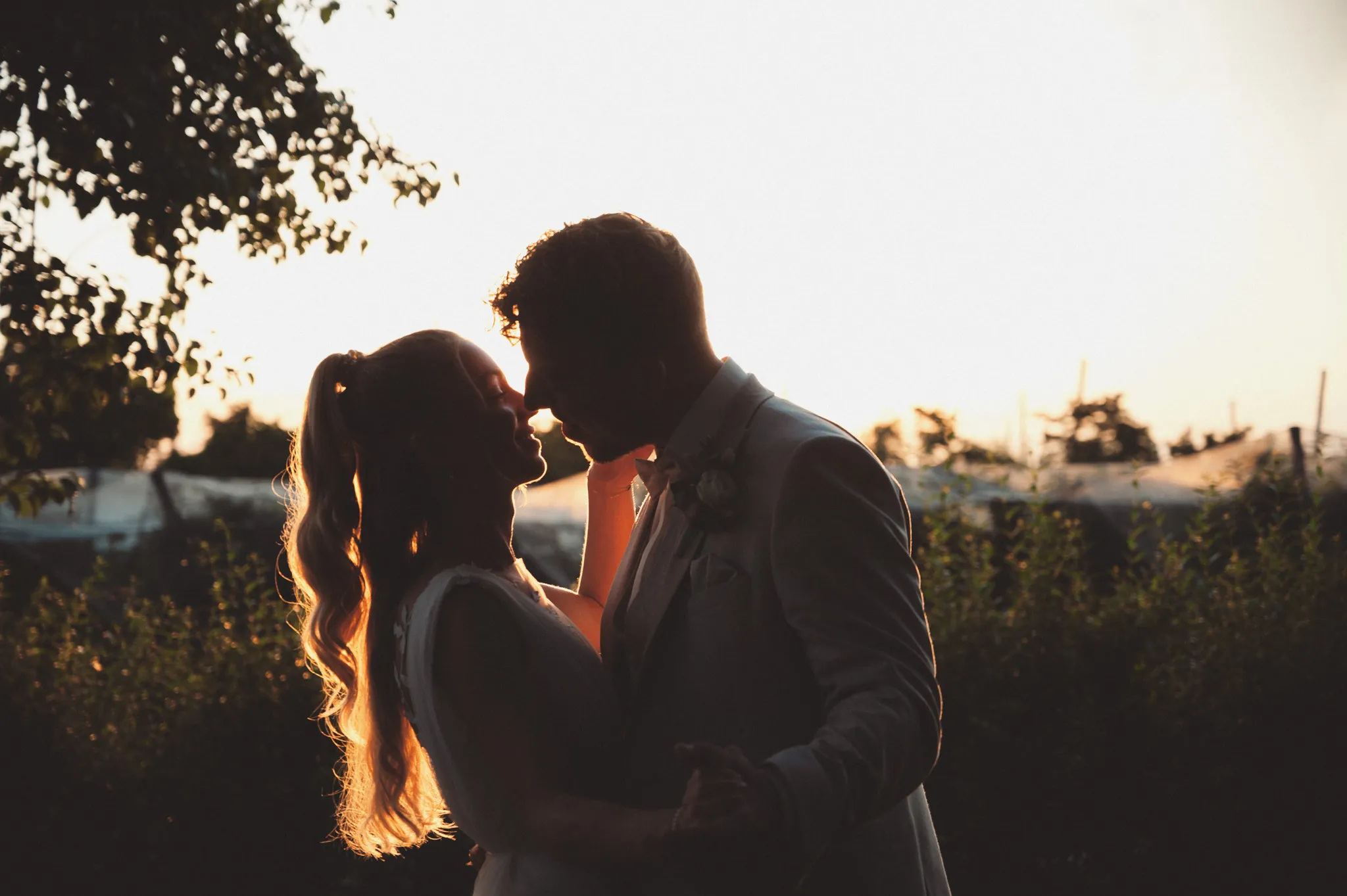Franziska und Daniel küssen sich als Silhouette im Abendlicht.