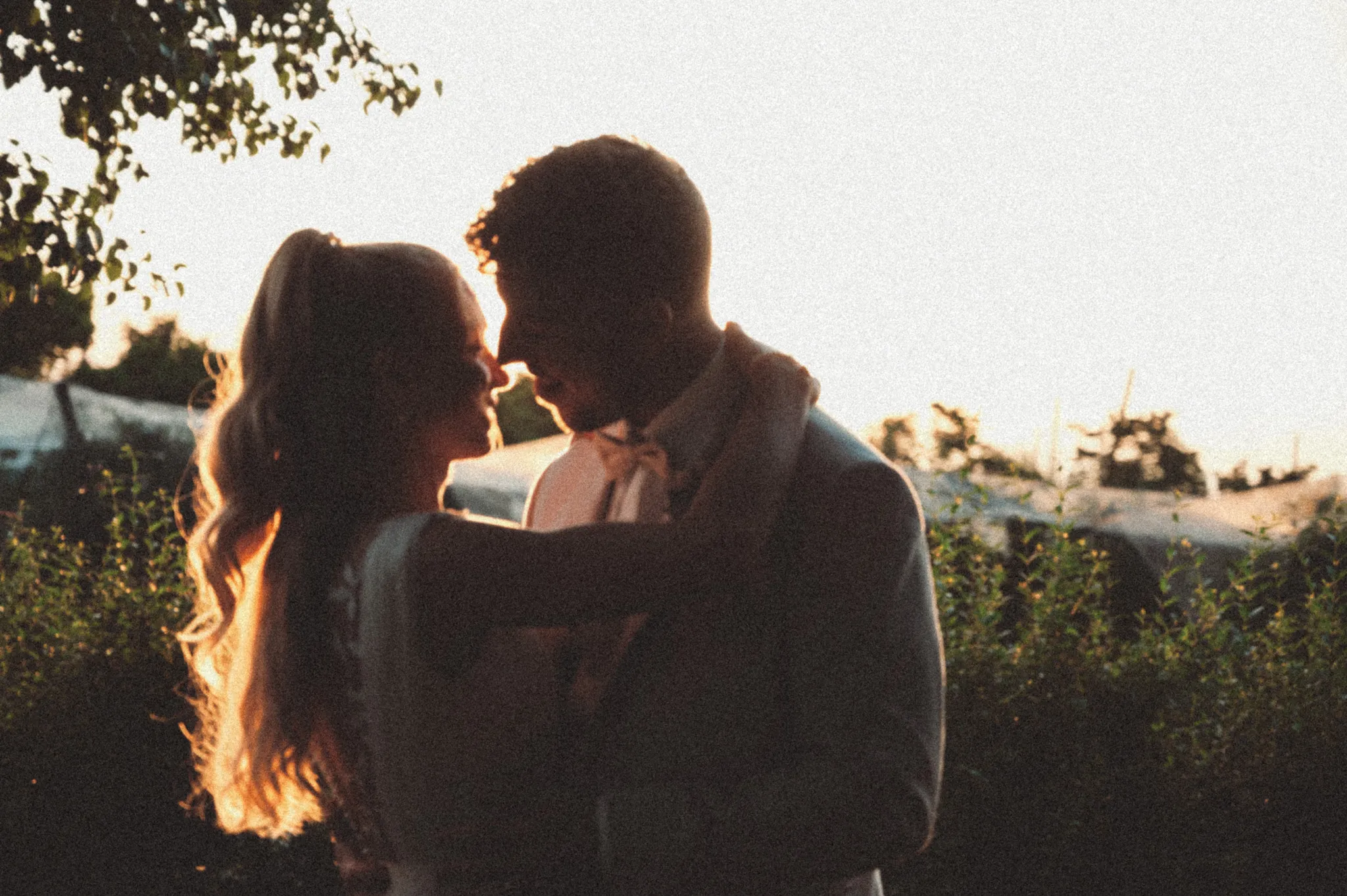 Franziska und Daniel berühren sich im Sonnenuntergang an der Stirn.