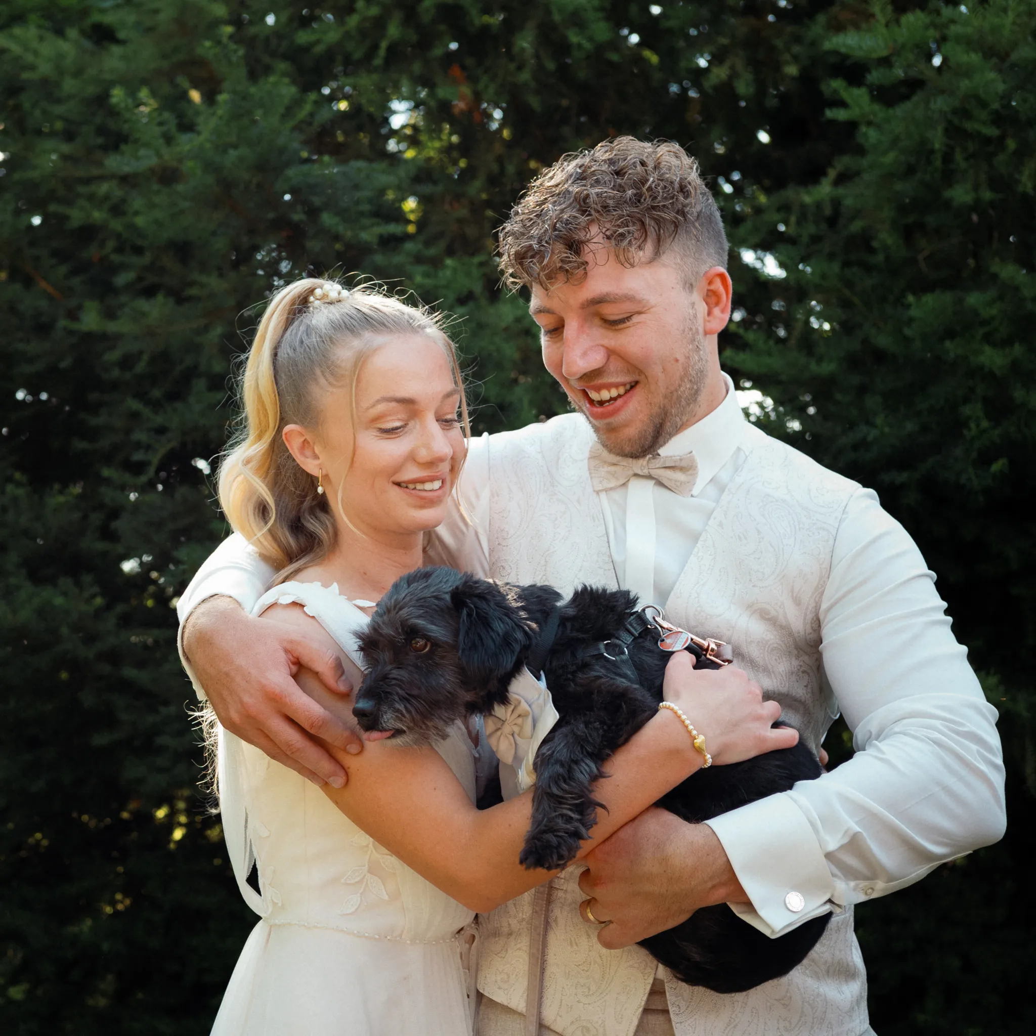 Franziska und Daniel halten gemeinsam einen kleinen Hund.