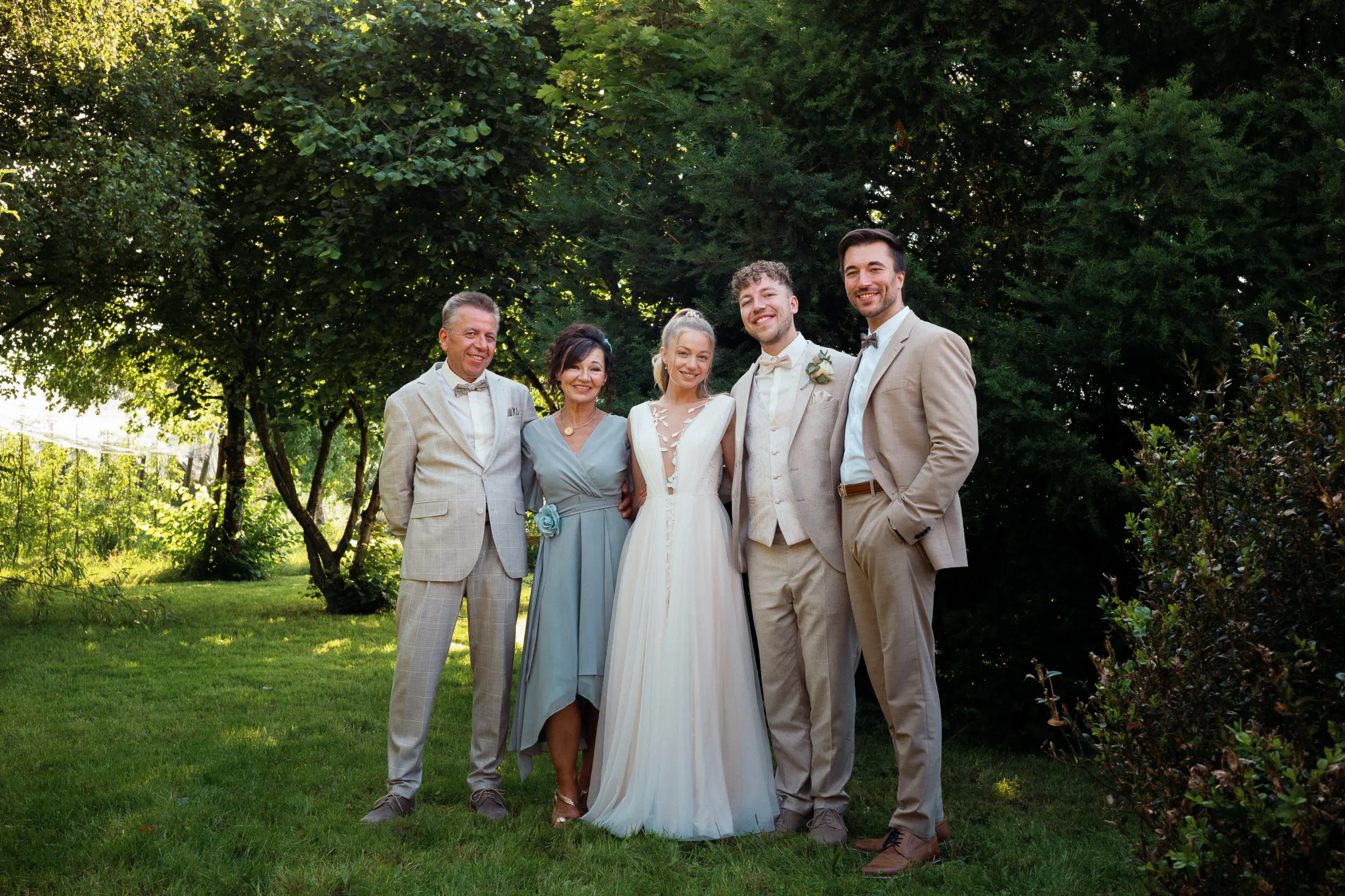 Franziska und Daniel stehen mit zwei Angehörigen unter Bäumen.