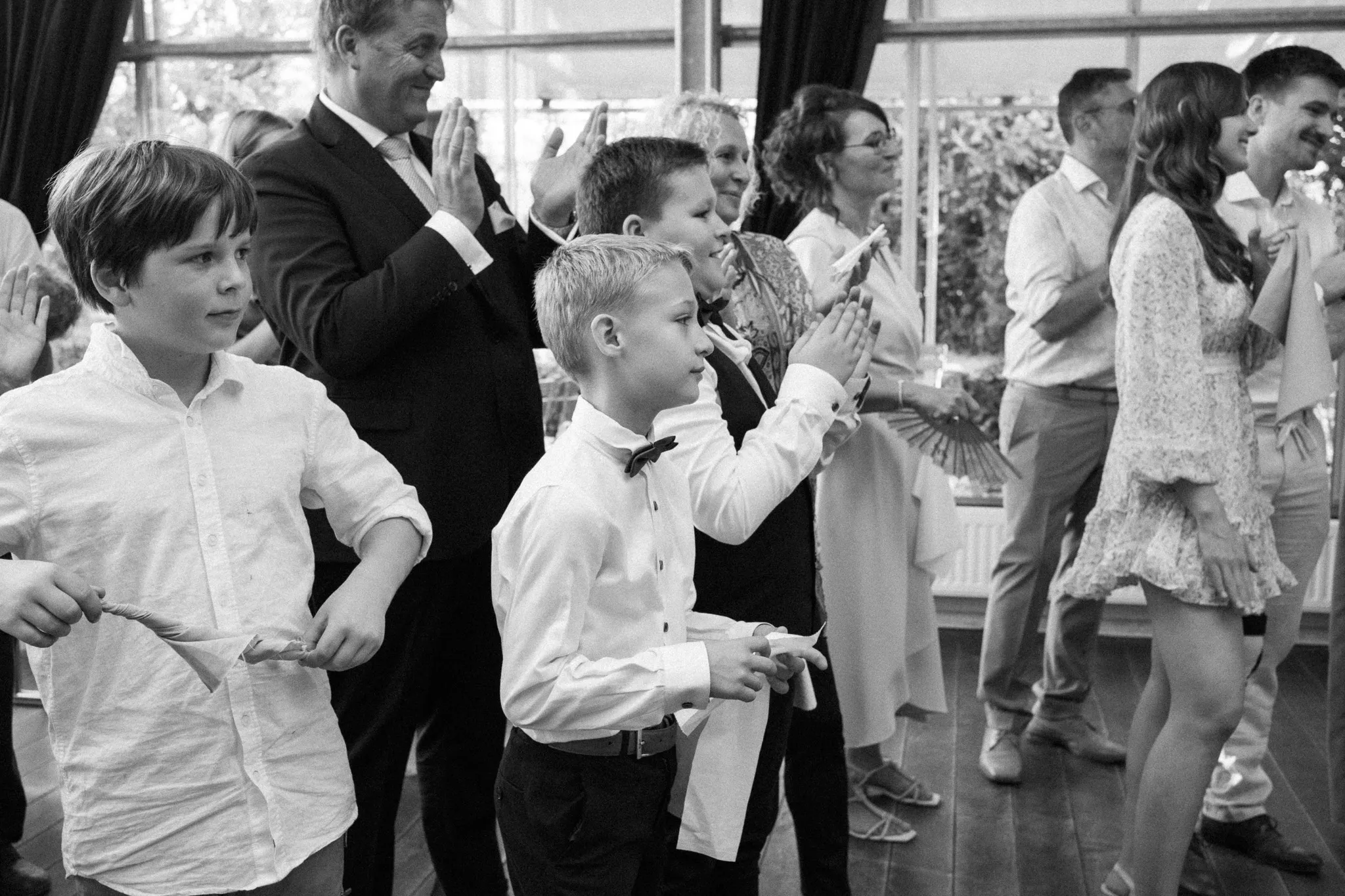 Kinder beobachten in einer Schwarz-Weiß-Aufnahme die Feier.