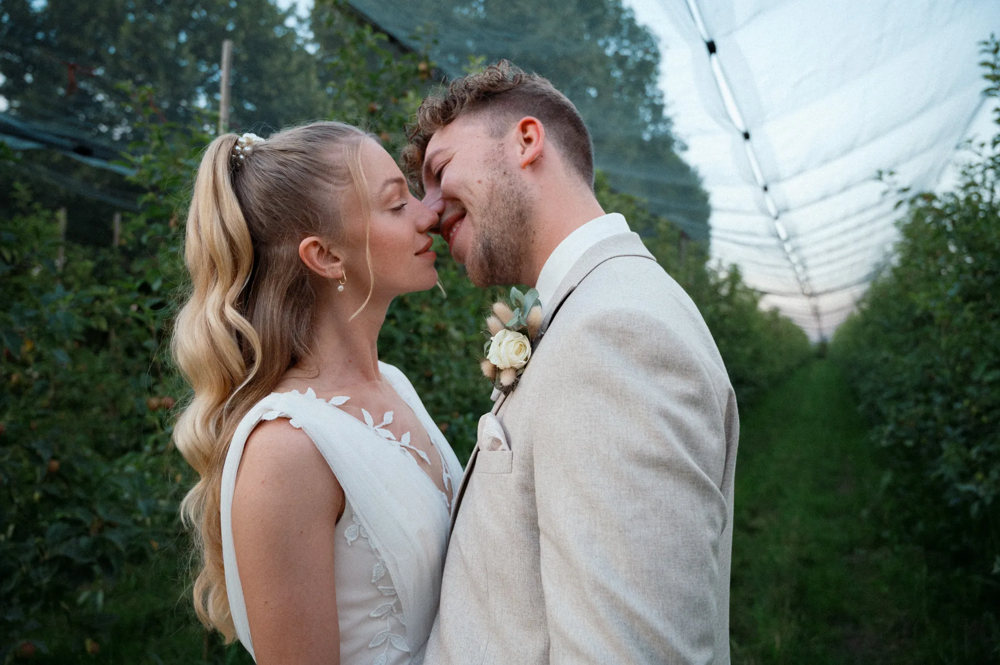 Franziska und Daniel küssen sich vor dem grünen Hintergrund.