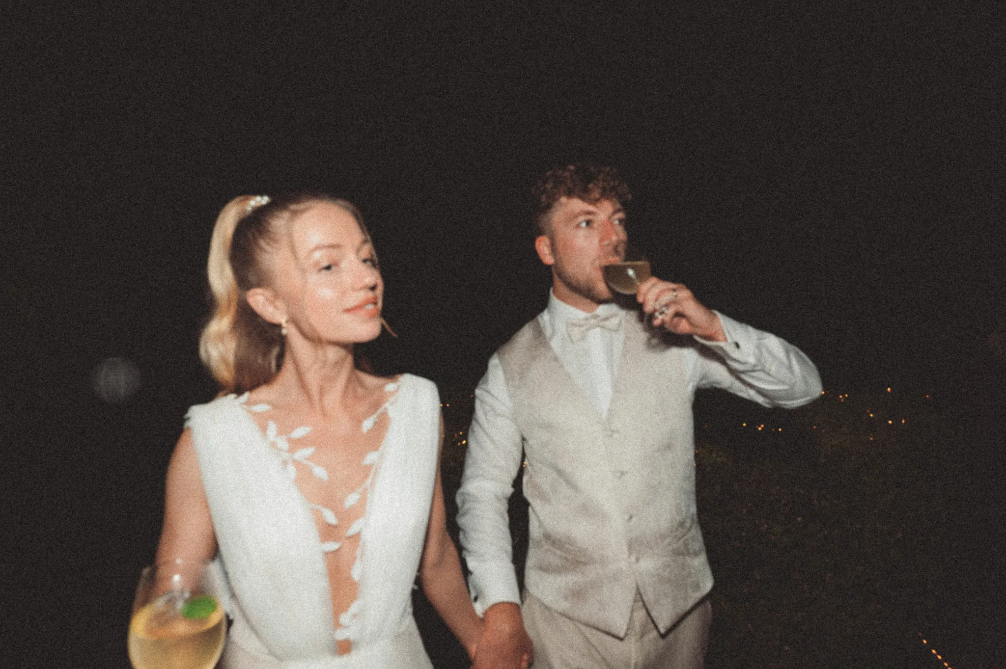 Franziska blickt Daniel an, während er aus seinem Glas trinkt.