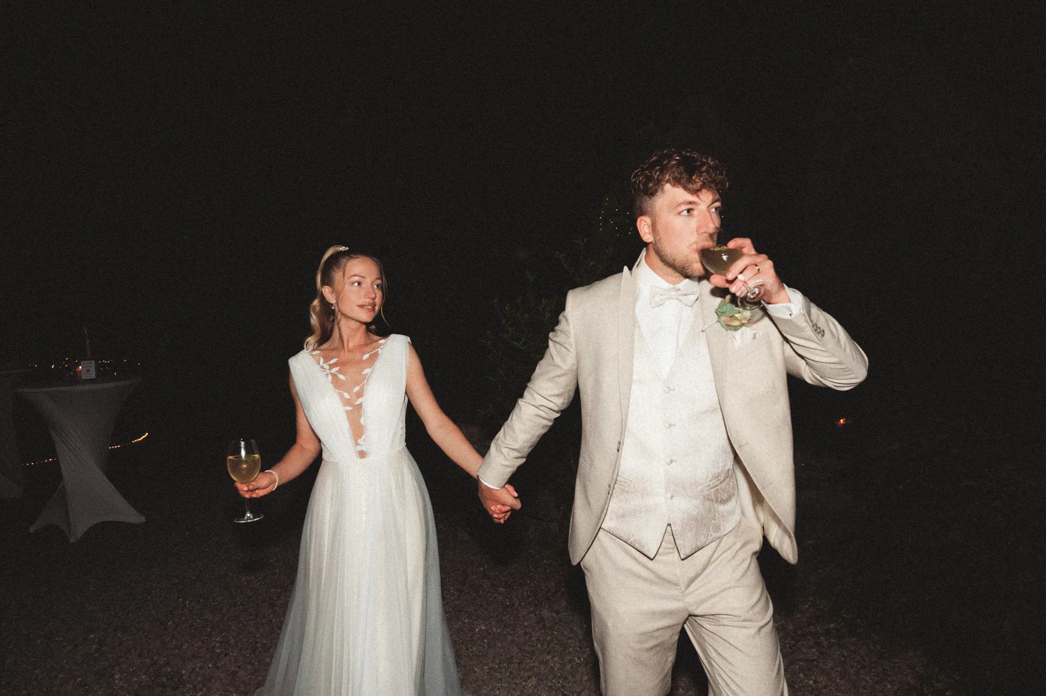 Franziska und Daniel laufen nachts lachend nebeneinander.
