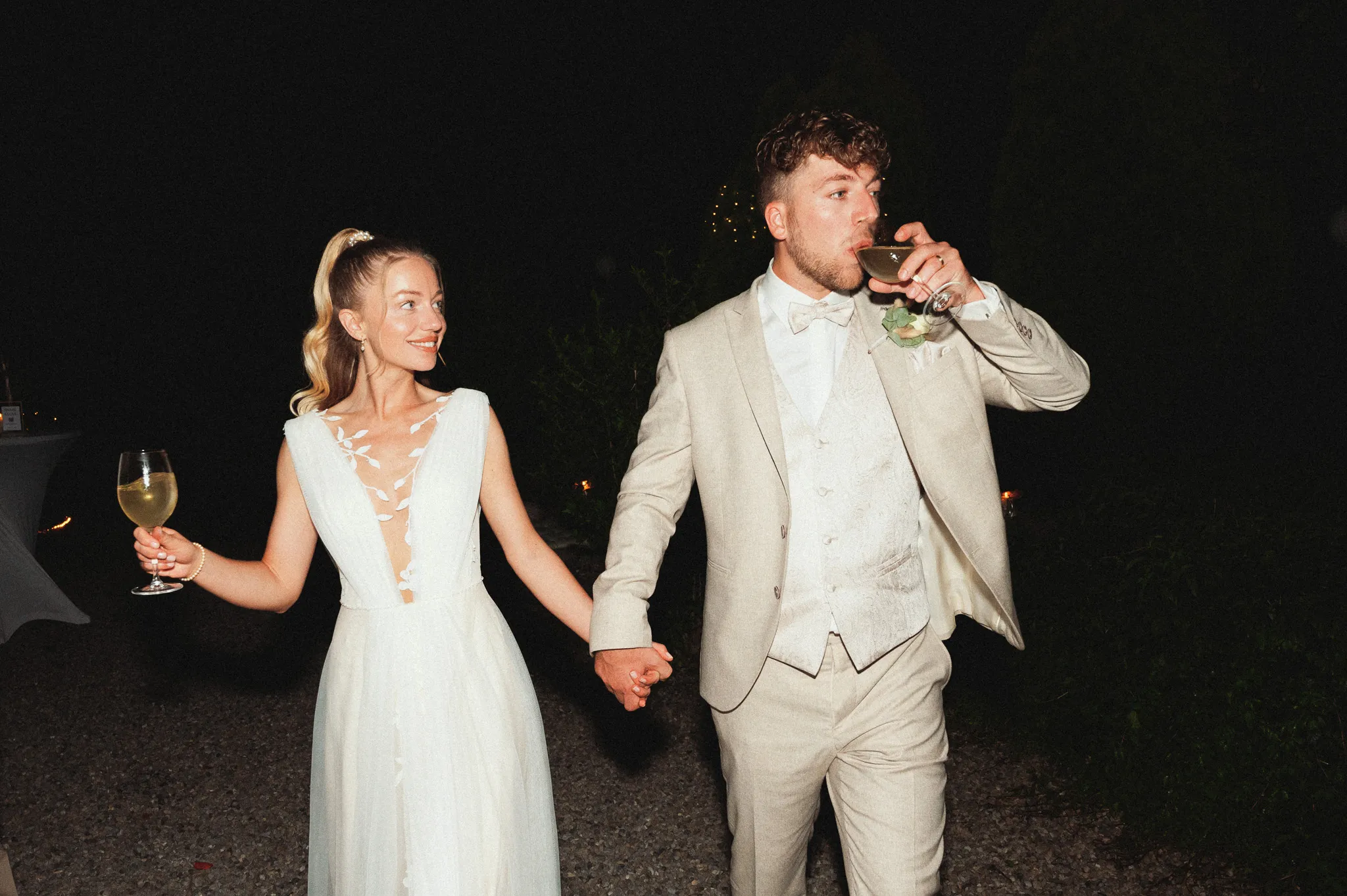 Franziska und Daniel gehen nachts Hand in Hand durch die Apfelplantage.