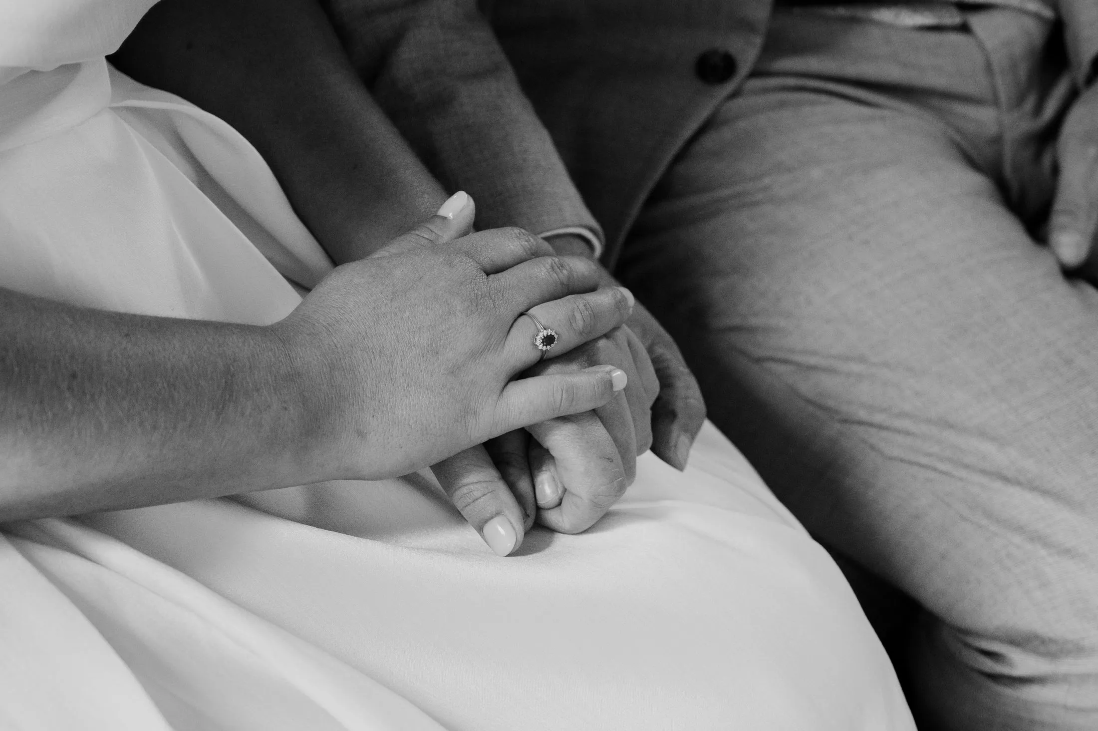 Nahaufnahme von Lisas Händen auf ihrem Hochzeitskleid.