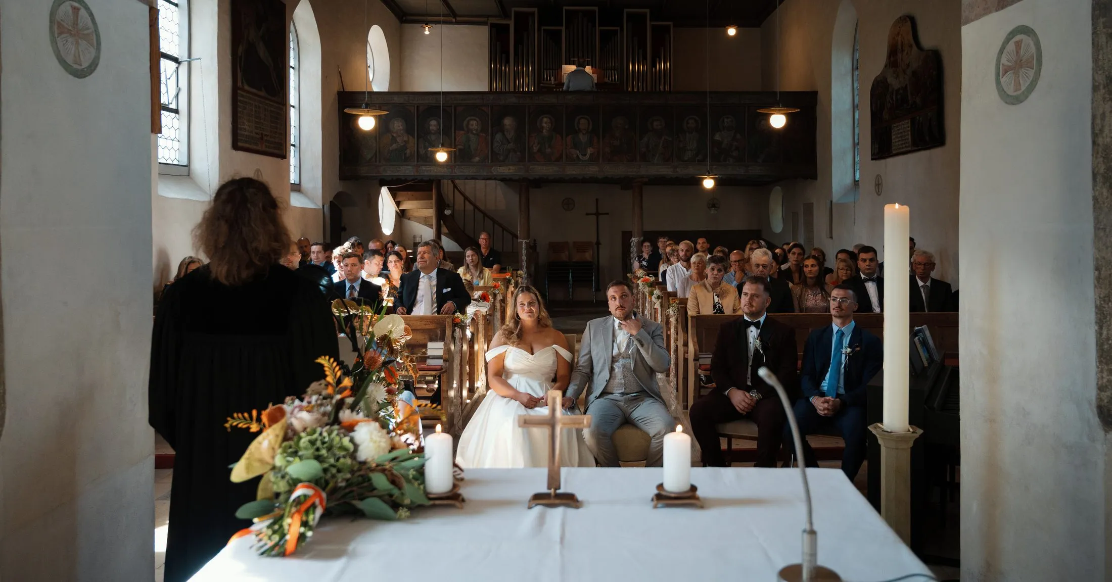 Gäste und Brautpaar während der Trauung in der Kirche.