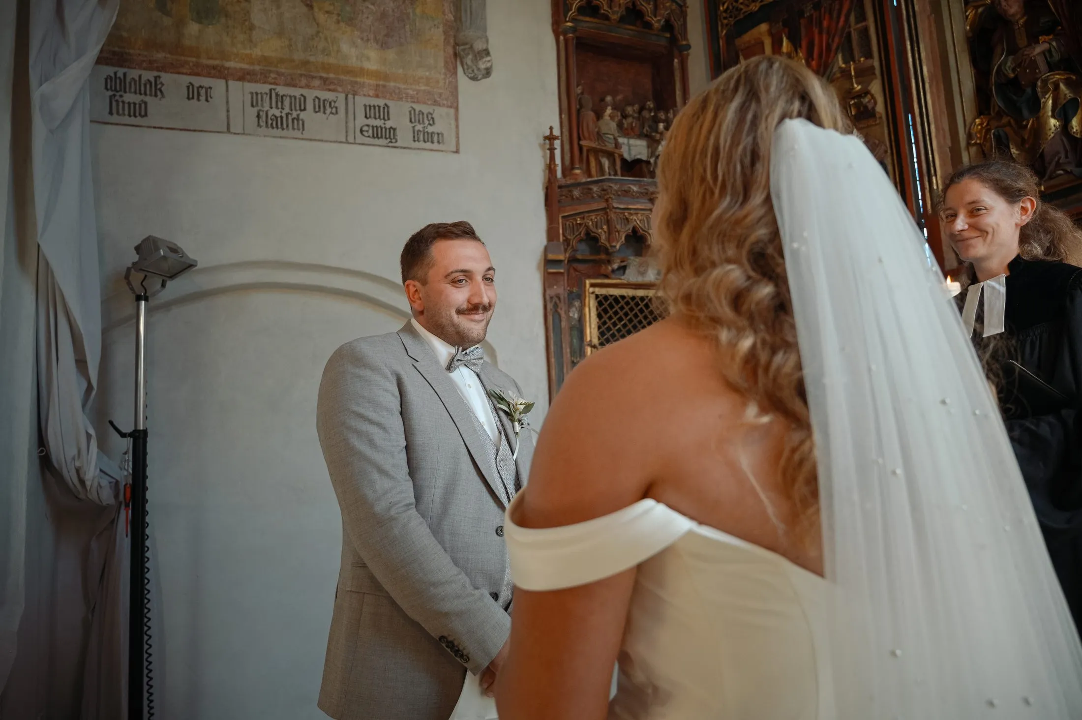 Gäste und Brautpaar während der Trauung in der Kirche.