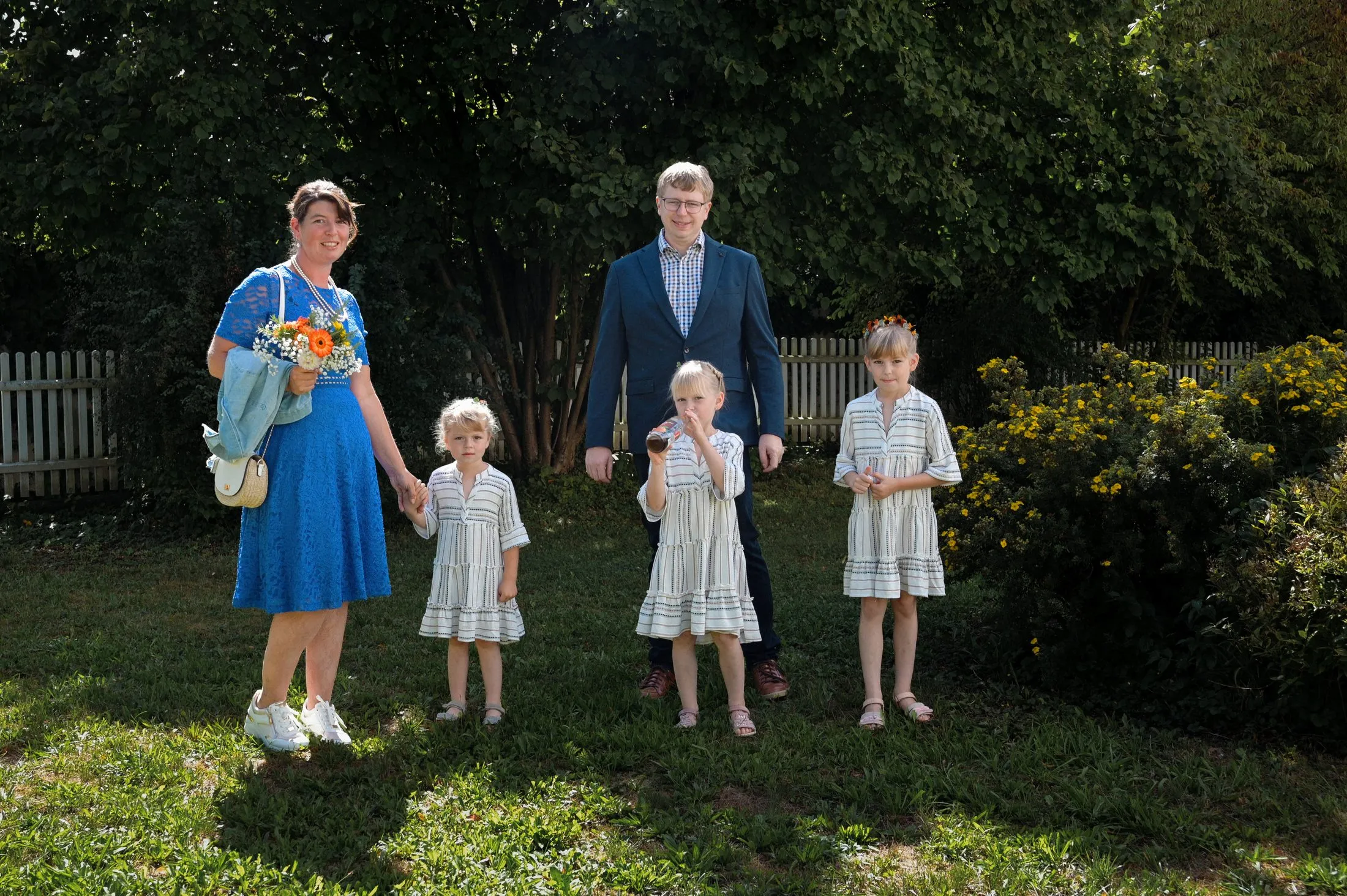 Eine Familie steht für ein gemeinsames Foto im Garten.
