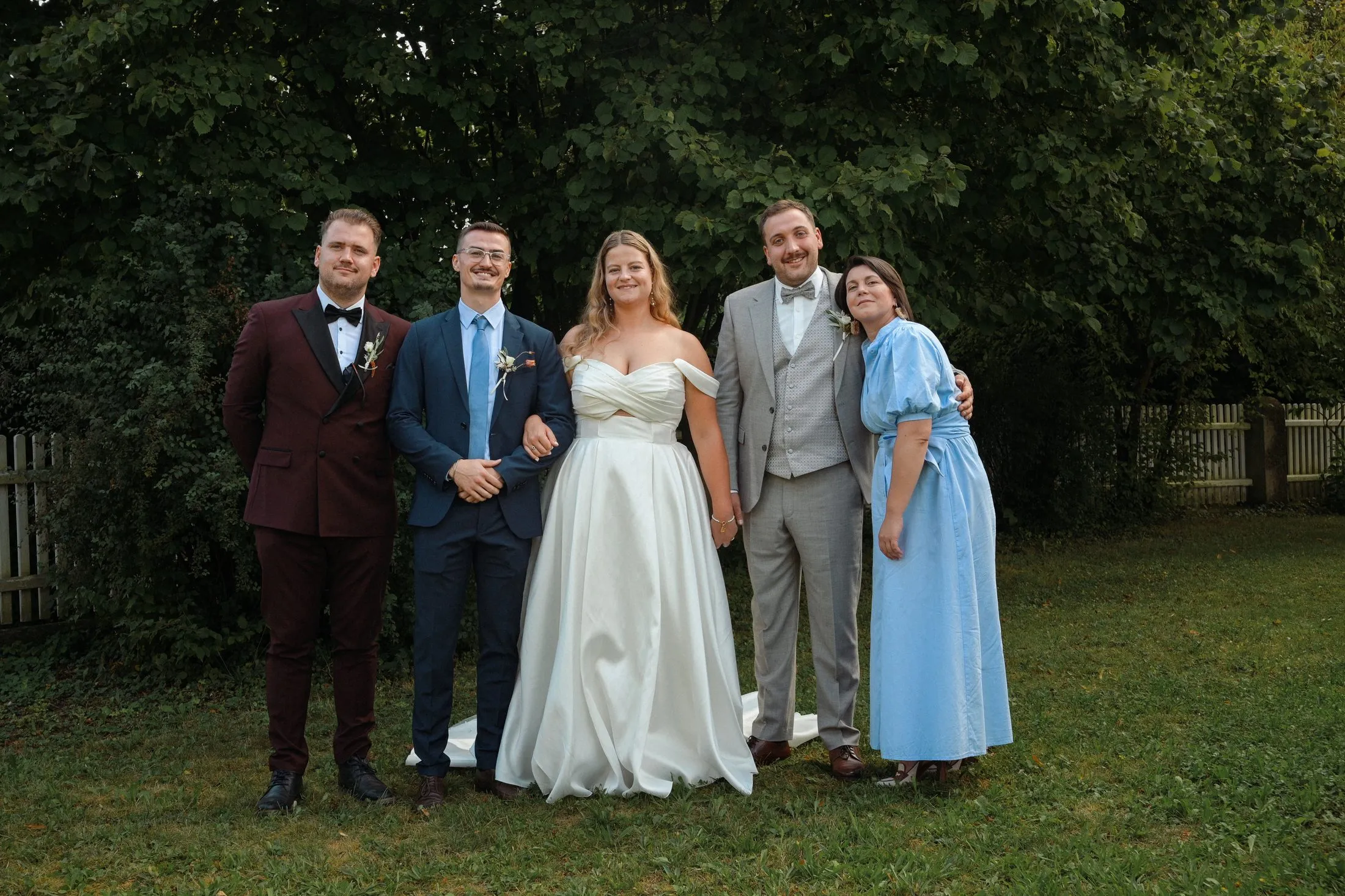 Hochzeitsgäste bei den Gruppenbildern im Garten.