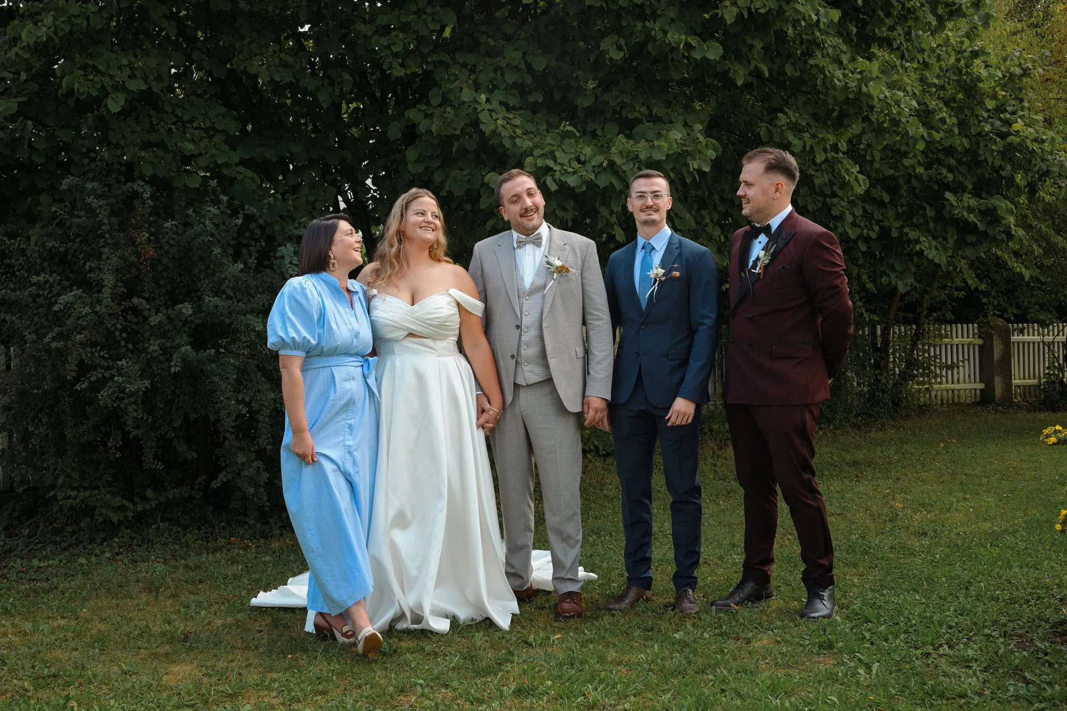 Ein Gruppenbild mit Hochzeitsgästen im Grünen.