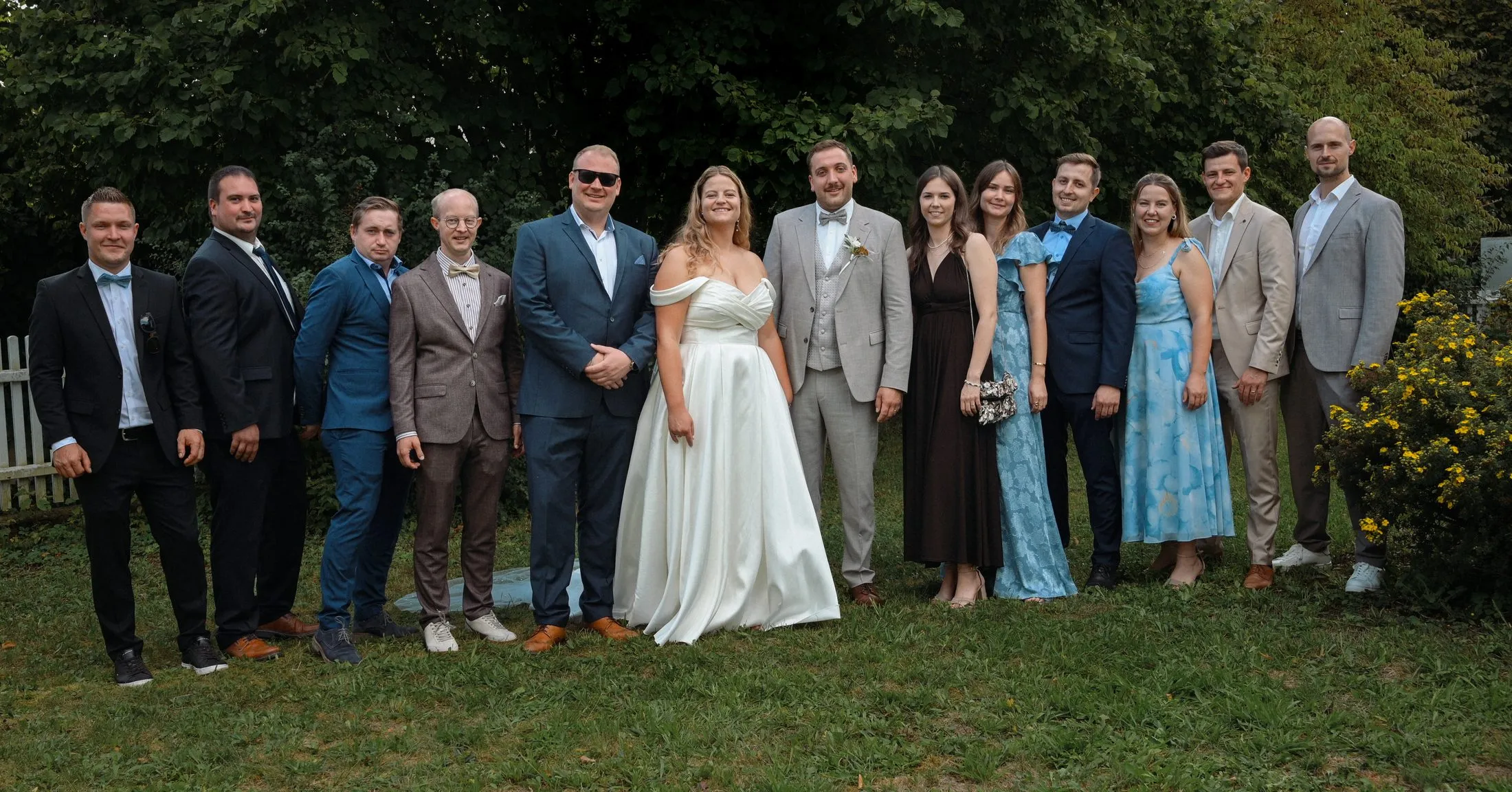 Ein Gruppenbild mit Hochzeitsgästen im Grünen.