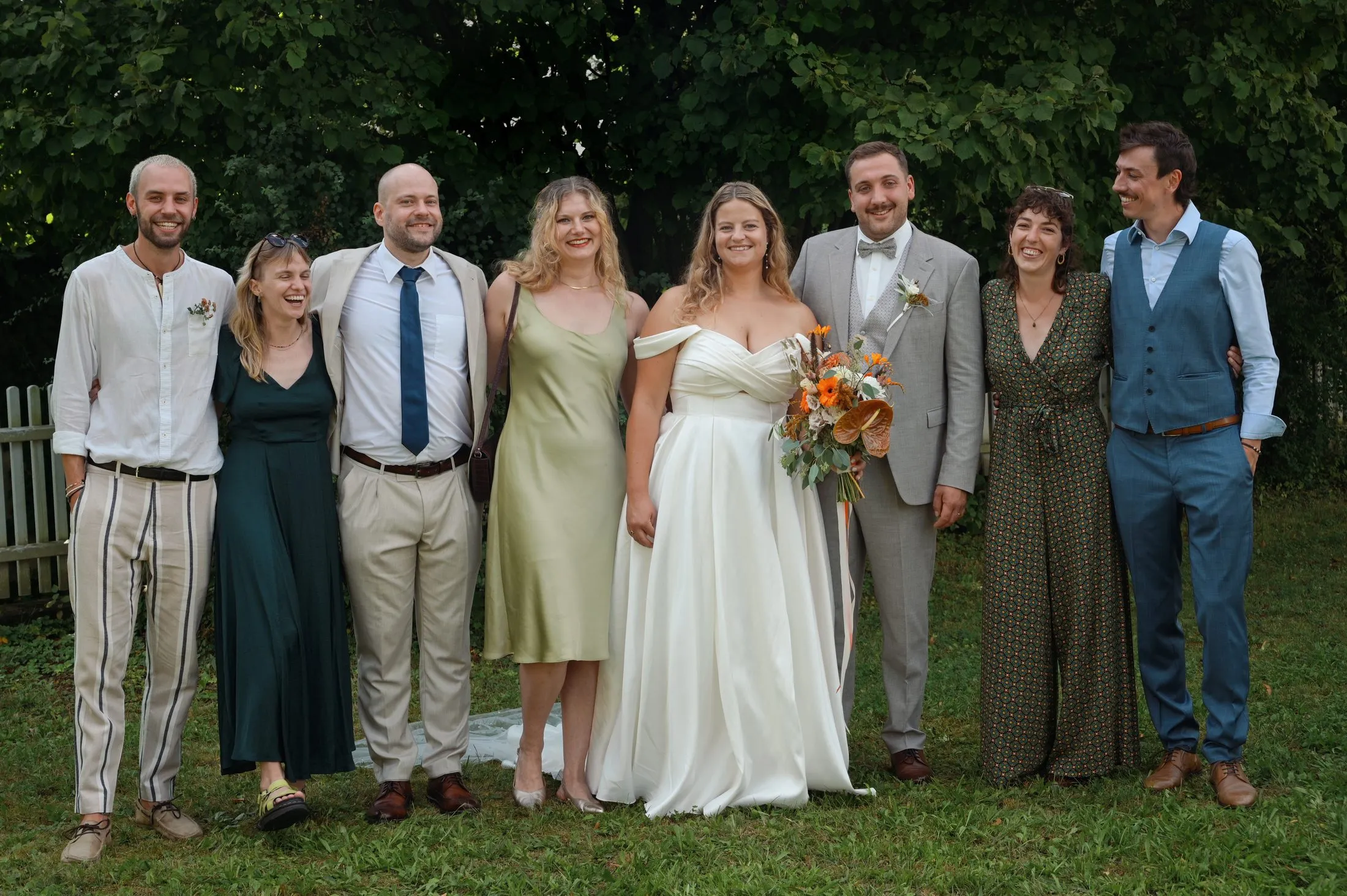 Ein Gruppenbild mit Hochzeitsgästen im Grünen.