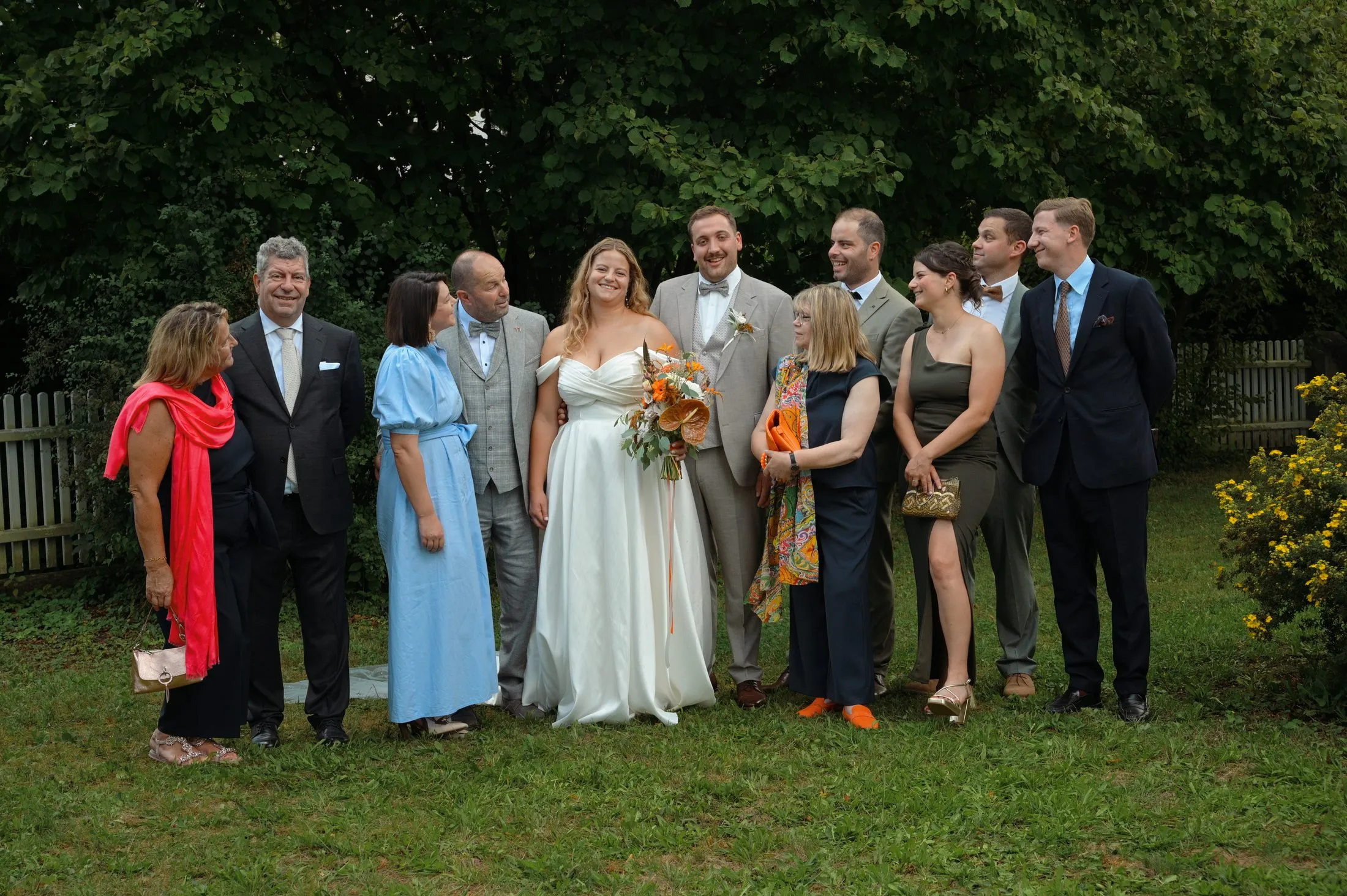 Ein Gruppenbild mit Hochzeitsgästen im Grünen.