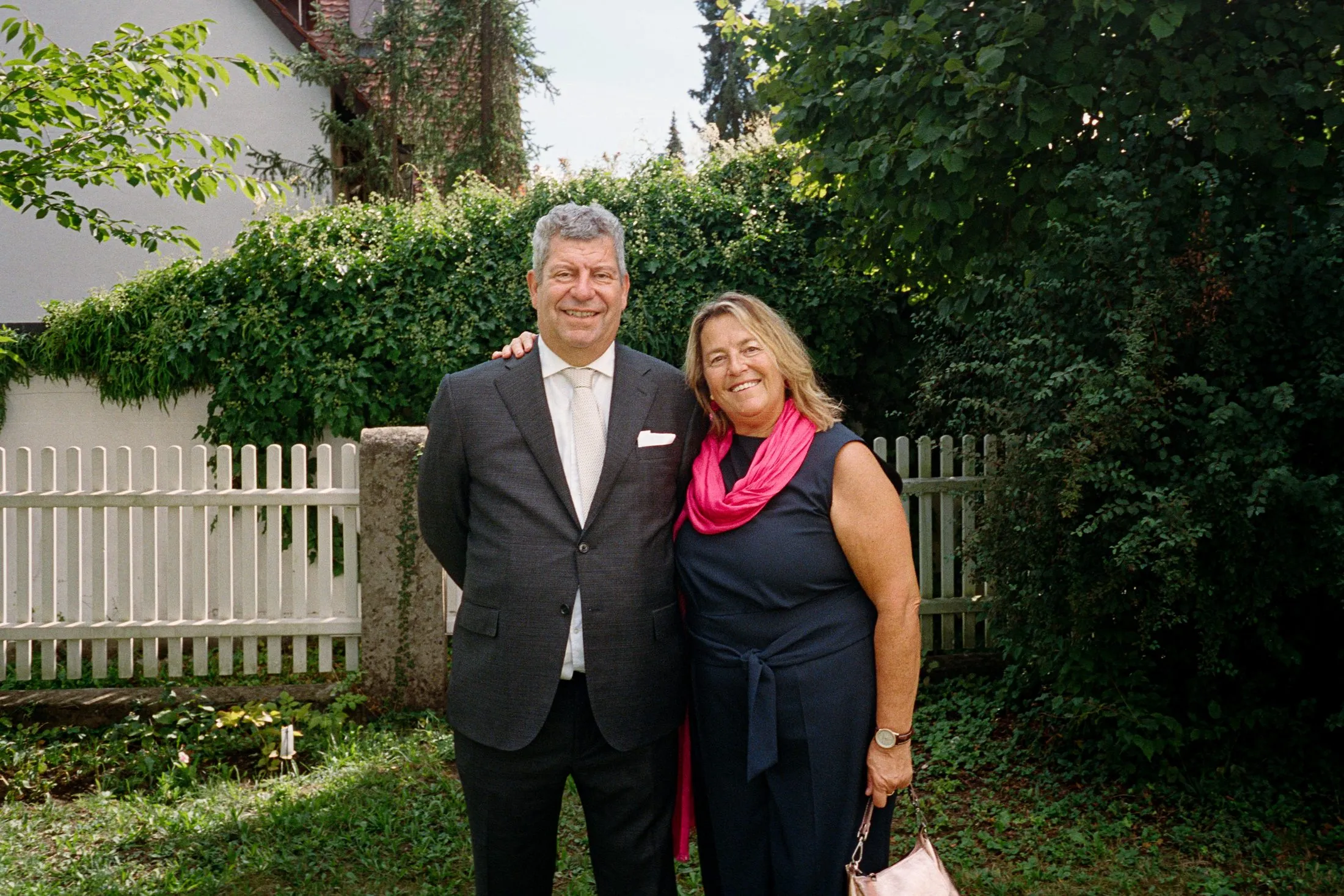 Zwei Hochzeitsgäste stehen für ein Foto im Garten.