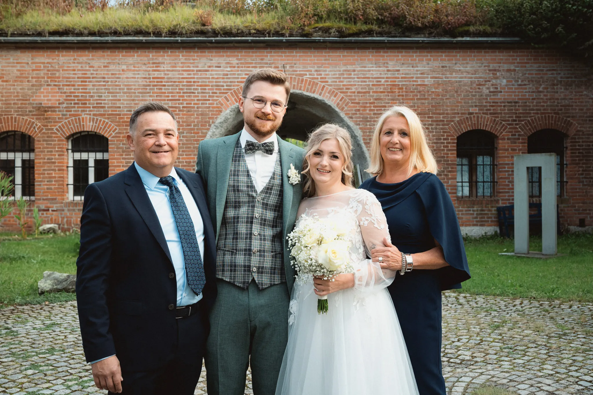 Tamara und Kevin lächeln gemeinsam mit zwei Gästen in die Kamera.
