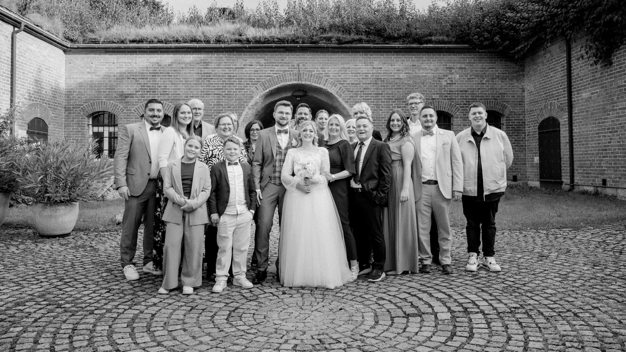 Tamara und Kevin stehen mit einer großen Gruppe in einer Schwarz-Weiß-Aufnahme zusammen.