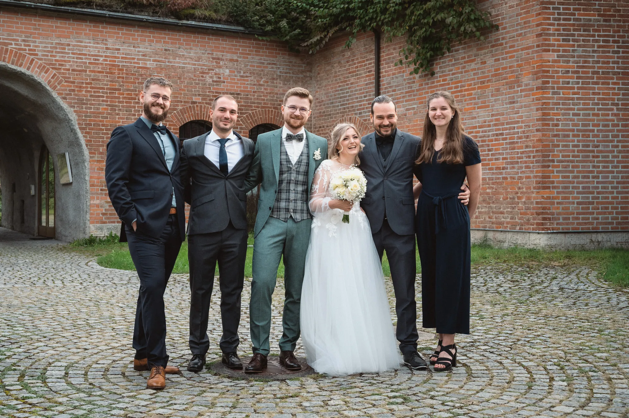 Tamara und Kevin stehen mit vier festlich gekleideten Gästen im Innenhof.