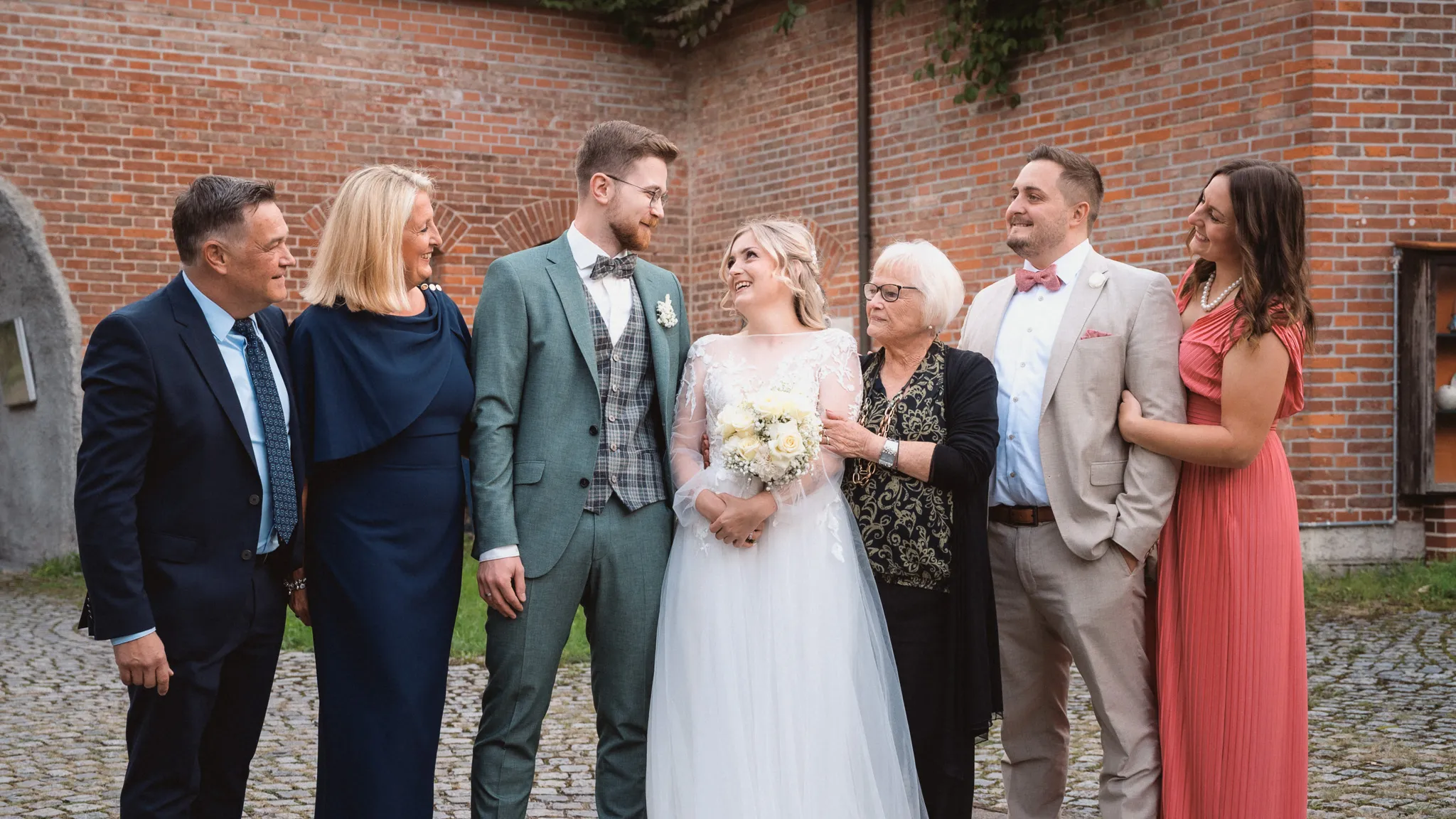 Tamara und Kevin lachen mit vier Gästen während eines lockeren Gruppenportraits.