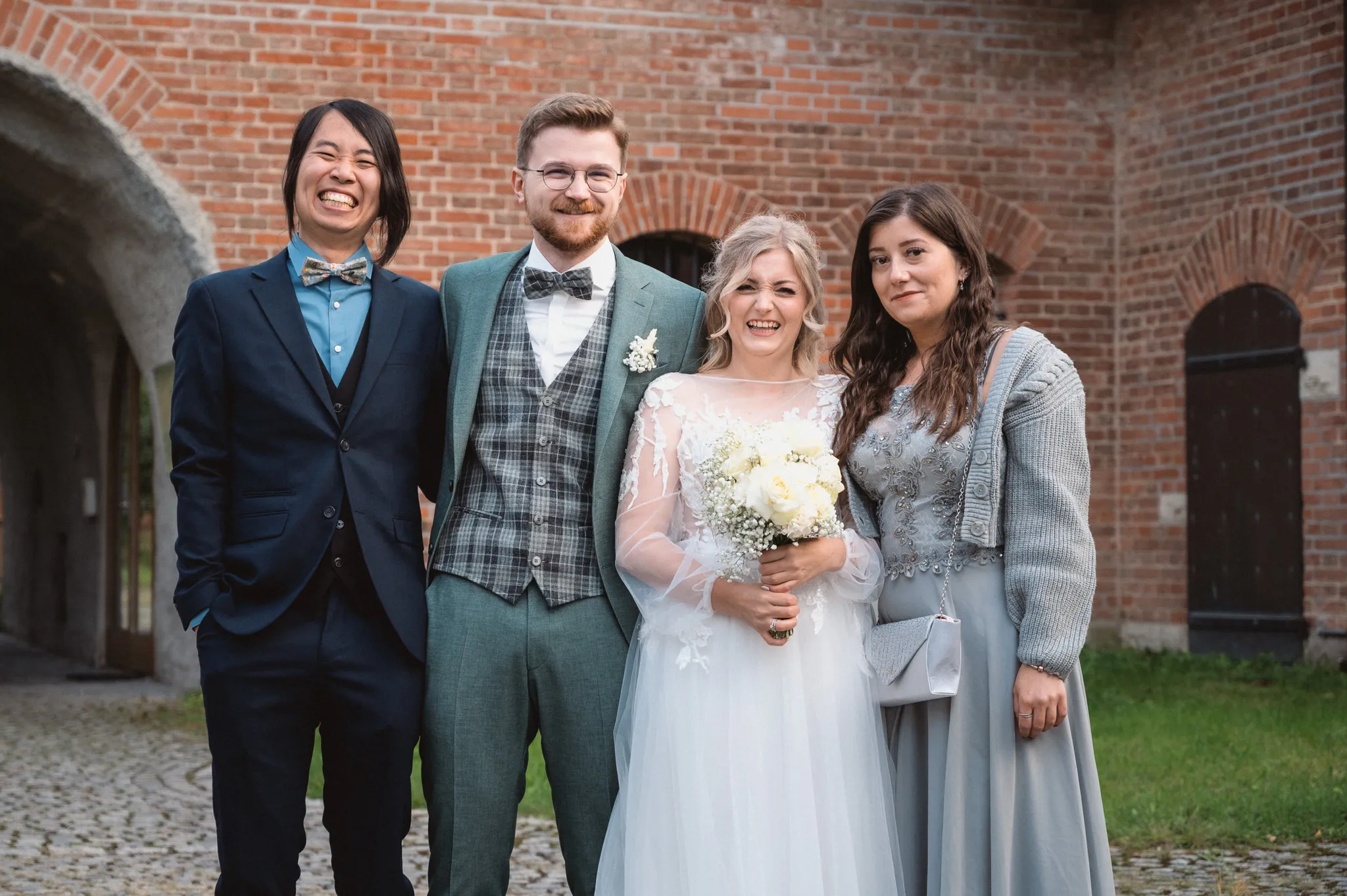Tamara und Kevin stehen mit zwei Gästen bei einem ruhigen Gruppenportrait.