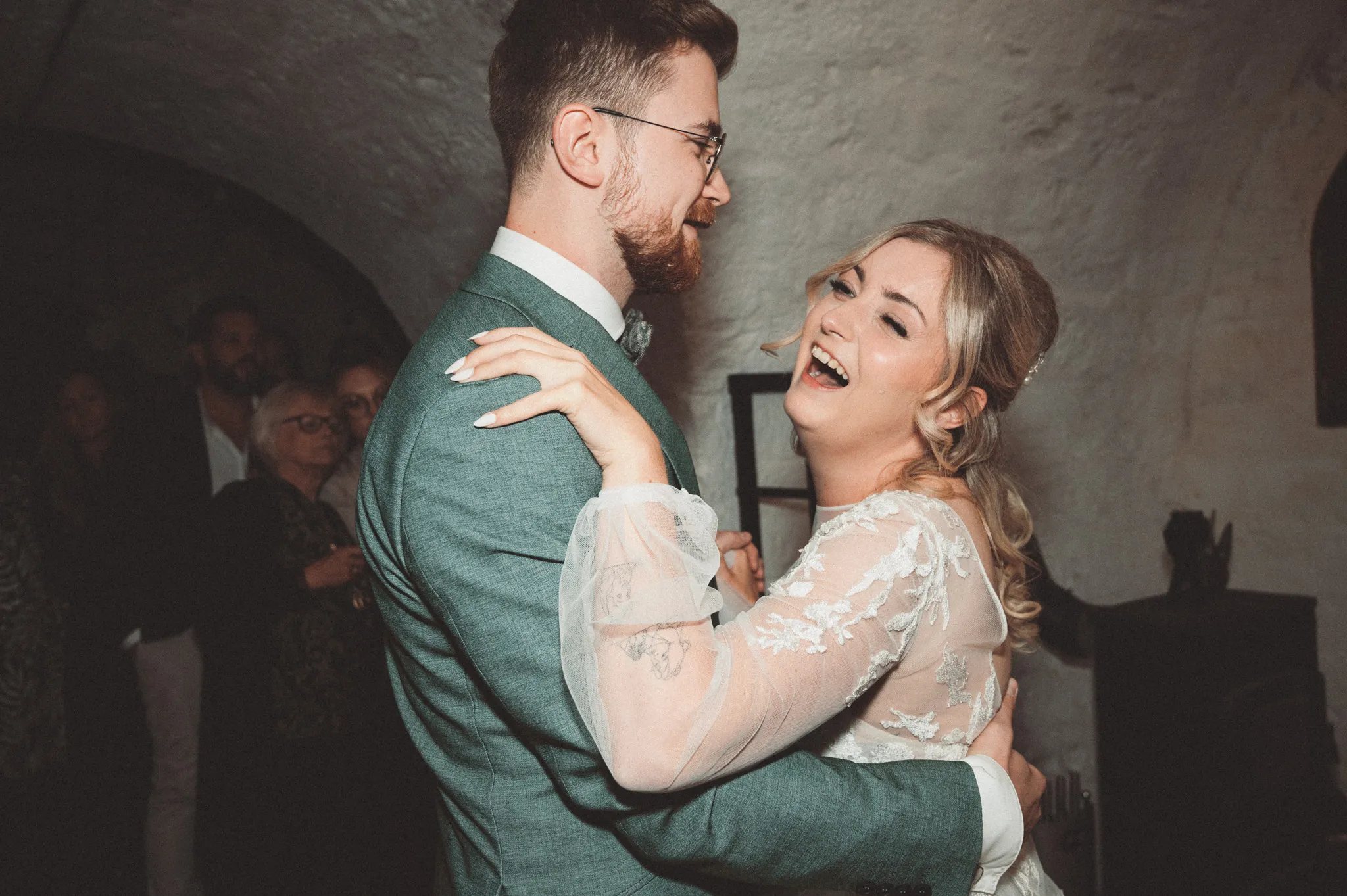 Tamara und Kevin lachen eng umschlungen während des Hochzeitstanzes.